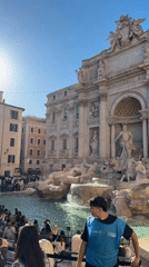 Crowds gather at sunny Trevi Fountain in Rome