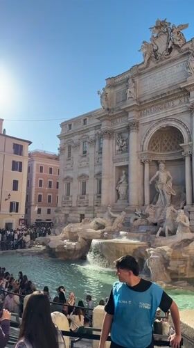 Crowds gather at sunny Trevi Fountain in Rome