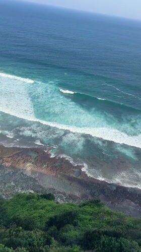 Cliffside rooftop bar scene with Bali coastal views
