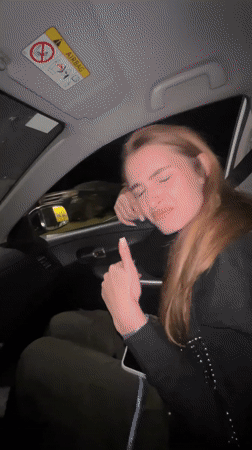 Woman makes hand gestures in passenger seat, Budva Montenegro