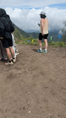 Group gathers around phone in Kintamani clearing