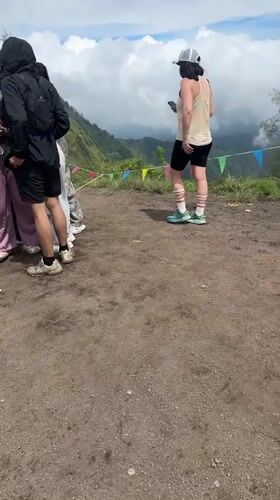 Group gathers around phone in Kintamani clearing