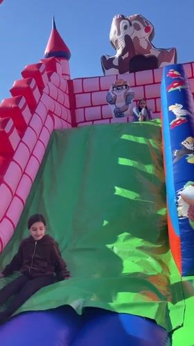 Children play on inflatable castle slide in Kichevo