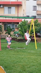 Kids playing outside in a Bucharest backyard on a summer afternoon.