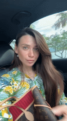 Woman in lemon-patterned blouse observed in driver's seat