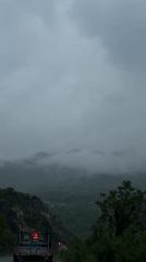Truck travels mountain road through green valley in Montenegro