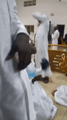 Late-night religious service documented with white-robed participants