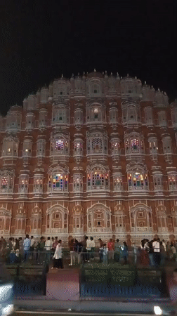 Nighttime crowds gather at illuminated Hawa Mahal in Jaipur