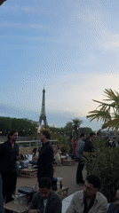Social gathering on Paris rooftop terrace near Eiffel Tower