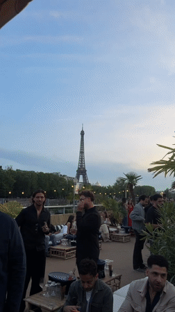 Social gathering on Paris rooftop terrace near Eiffel Tower