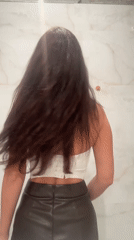 Woman in white top adjusts hair in Gavrilkovo
