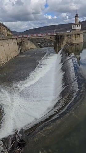 Water flows over concrete dam in Bulgarian village