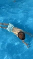 Kids splashing around in a pool and on an inflatable water slide