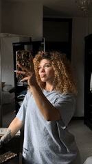Woman takes mirror selfies in London bedroom during morning session