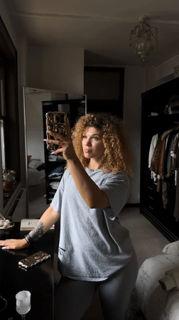 Woman takes mirror selfies in London bedroom during morning session
