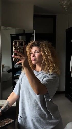 Woman takes mirror selfies in London bedroom during morning session