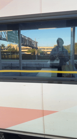 Late night train passenger travels through Aventura using phone