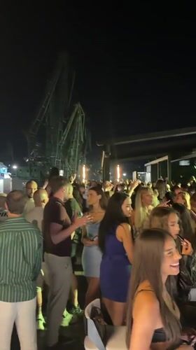Outdoor night gathering near cranes in Varna, Bulgaria