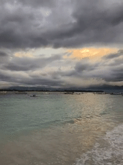 Dramatic golden light breaks through storm clouds over Indonesian coast