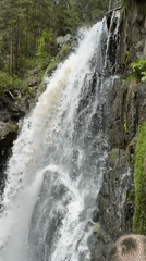 Waterfall documented cascading through green landscape near Barangol, Russia