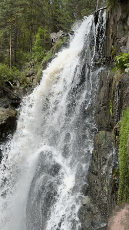Waterfall documented cascading through green landscape near Barangol, Russia