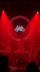 Dancers in white perform in front of an 'Aldo' branded stage backdrop