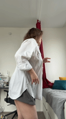 Woman dancing, adjusting curtains in apartment morning routine