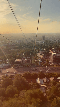 Cable car climbing above Almaty, city sprawling below