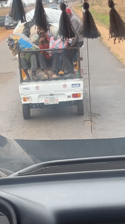 Loaded pickup truck carries passengers on Nigerian road