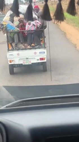 Loaded pickup truck carries passengers on Nigerian road