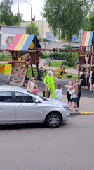 Performer in green dances for children at Belarus playground
