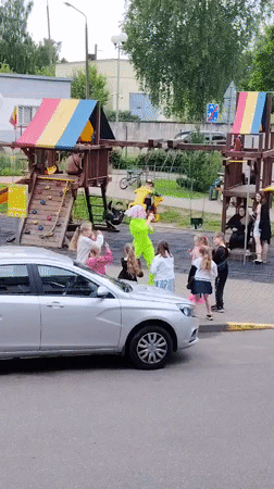 Performer in green dances for children at Belarus playground
