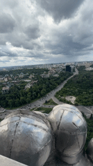 Aerial views of Kyiv monument and cityscape under cloudy skies