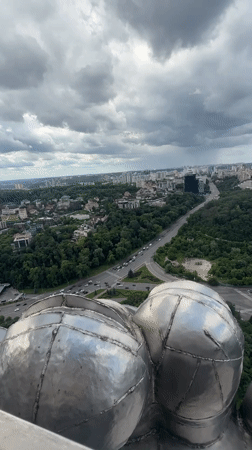 Aerial views of Kyiv monument and cityscape under cloudy skies