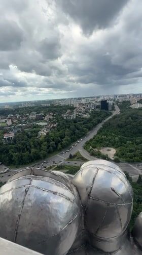 Aerial views of Kyiv monument and cityscape under cloudy skies