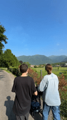 Family walks with stroller along mountain path in Erba