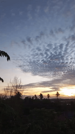 Dawn breaks over Lhokseumawe with layered clouds and golden horizon