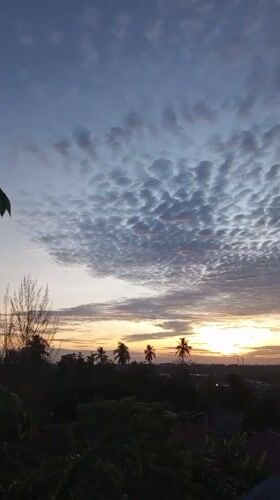 Dawn breaks over Lhokseumawe with layered clouds and golden horizon