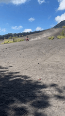 Motorcyclist rides volcanic terrain near Kintamani, Indonesia
