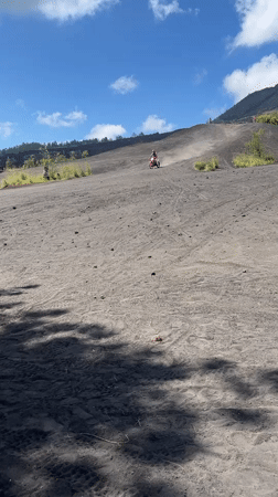 Motorcyclist rides volcanic terrain near Kintamani, Indonesia