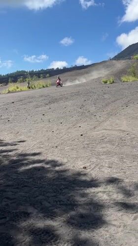 Motorcyclist rides volcanic terrain near Kintamani, Indonesia