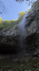 Waterfall flows into pool amid greenery in Veselinovo, Bulgaria