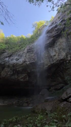 Waterfall flows into pool amid greenery in Veselinovo, Bulgaria