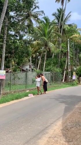 Two women stand on roadside in Kabalana, Sri Lanka