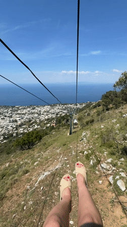 Tourist rides Monte Solaro chairlift capturing scenic Anacapri views