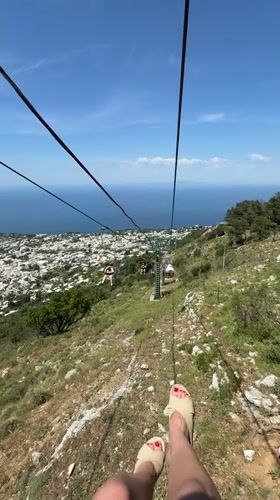 Tourist rides Monte Solaro chairlift capturing scenic Anacapri views