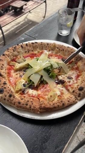 Person cuts pizza with scissors in Tel Aviv