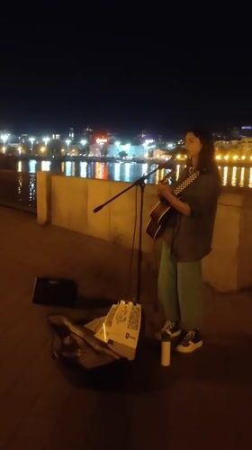 Acoustic street performance on a paved walkway at night