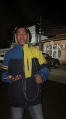 Young man dances with headphones outside Bulgarian cafe at night