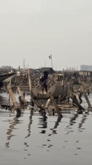Person poles makeshift concrete boat through Lagos waterway